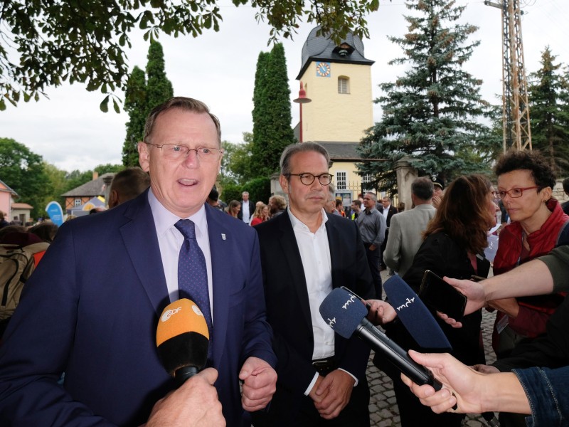 Bodo Ramelow (Linke, l), Ministerpräsident von Thüringen, spricht am Rande einer Kundgebung neben Georg Maier (M, SPD), Innenminister von Thüringen, mit Medienvertretern. 