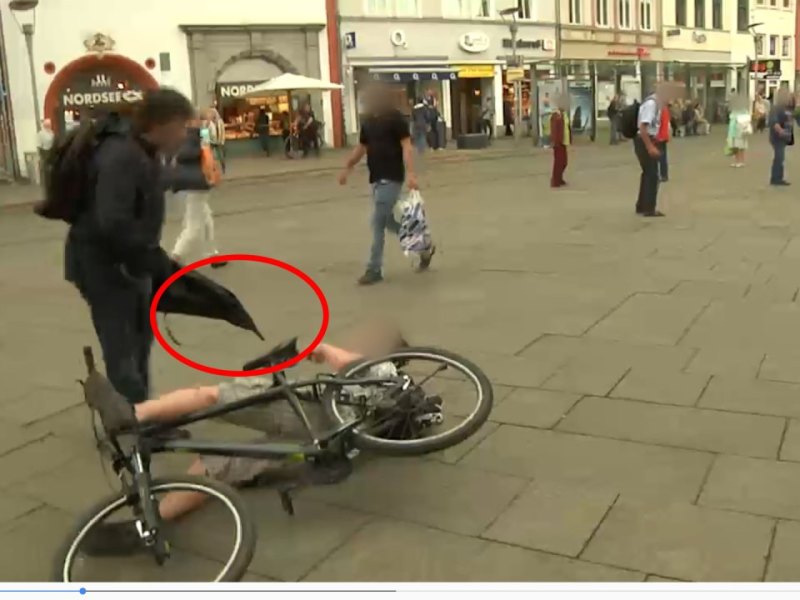 Mann greift mit Regenschirm Fahrradfahrer am Erfurter Anger an