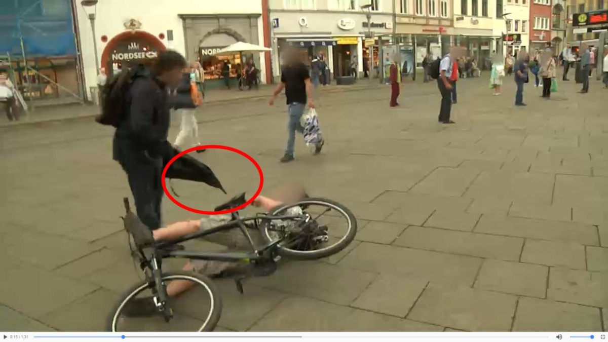 Mann greift mit Regenschirm Fahrradfahrer am Erfurter Anger an