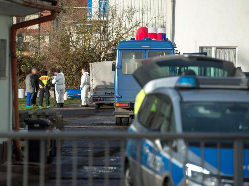 Polizisten stehen auf einem umzäunten Grundstück in Nordhausen. Hier haben Nachbarn das tote Ehepaar gefunden.