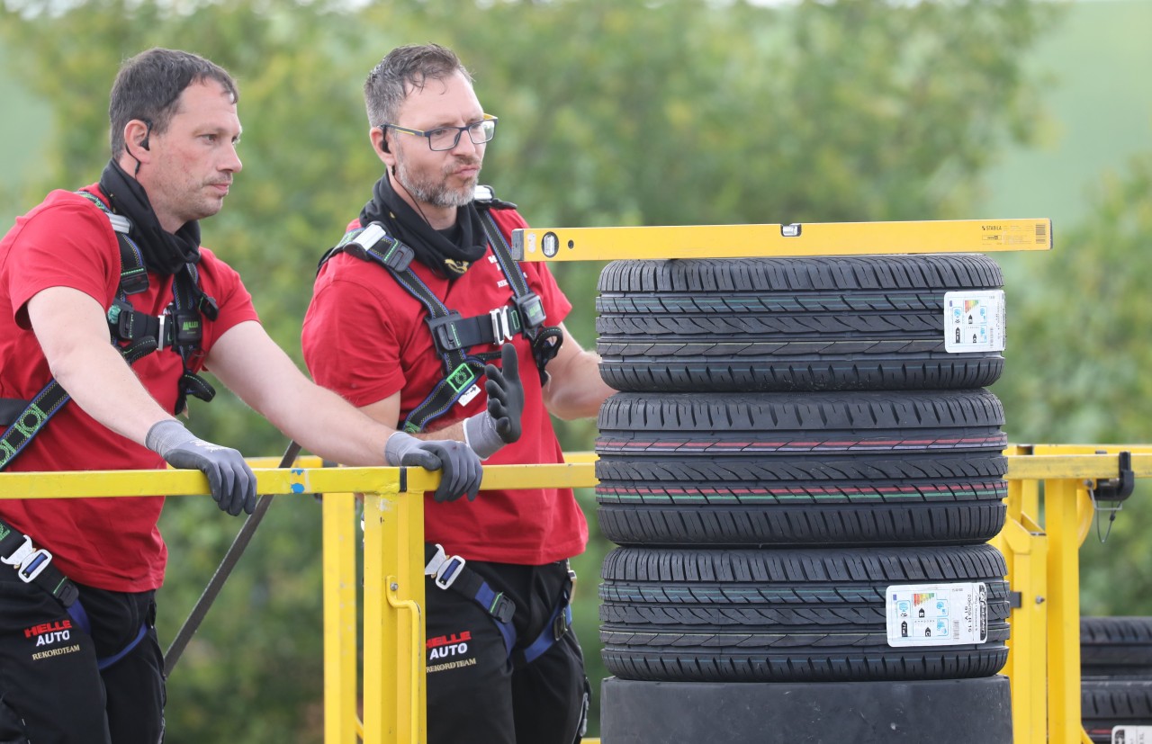  Daniel (l) und Marcel vom Verein We4Kids messen mit einer Wasserwaage einen Reifenstapel aus. Mit einer Gesamthöhe von 7,05 Metern erreichten sie einen neuen Weltrekord.