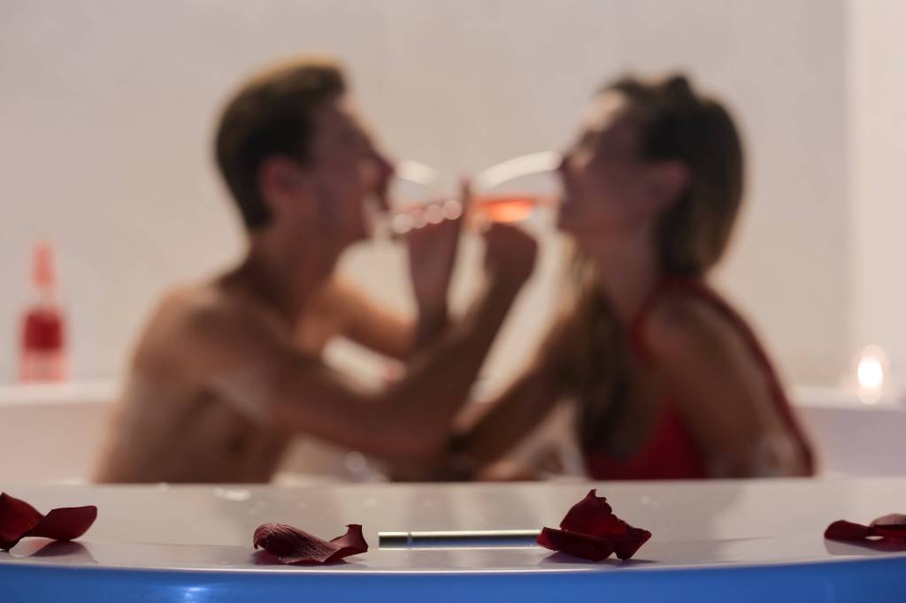 Verliebtes Paar. Frau und Mann trinken Sekt im Whirlpool