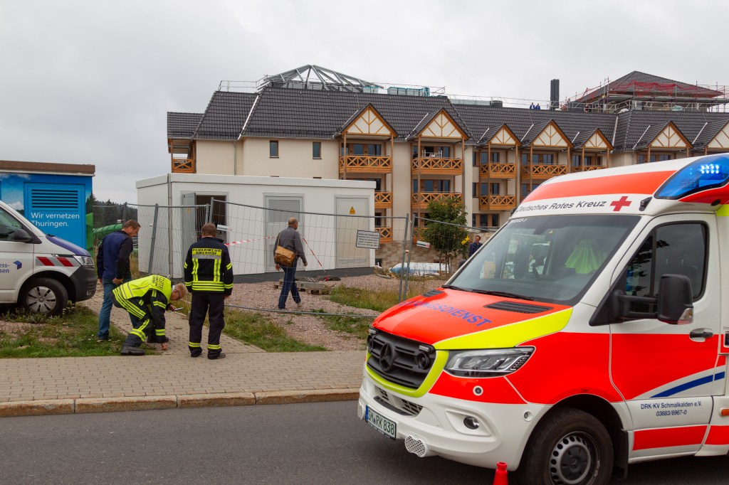 Rettungswagen steht vor Trafohäuschen mit Feuerwehrmännern davor