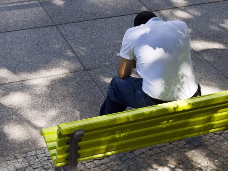 Jena Mann sitzt auf der Bank