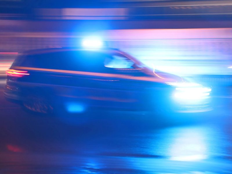 Streifenwagen fährt mit Blaulicht in er Nacht