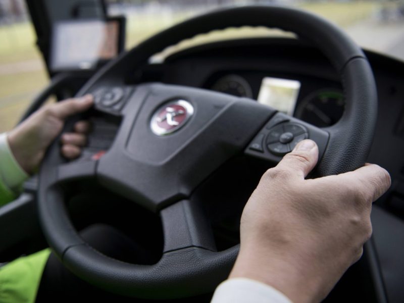 Mann hält Lenkrad im Bus in den Händen