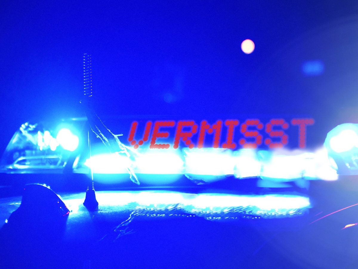 Streifenwagen der Polizei bei Nacht, mit der Blaulicht Aufschrift: Vermisst. Symbolbild