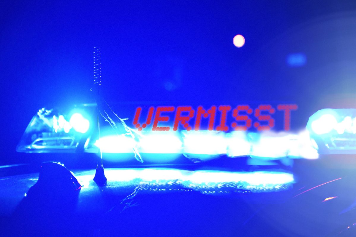 Streifenwagen der Polizei bei Nacht, mit der Blaulicht Aufschrift: Vermisst. Symbolbild