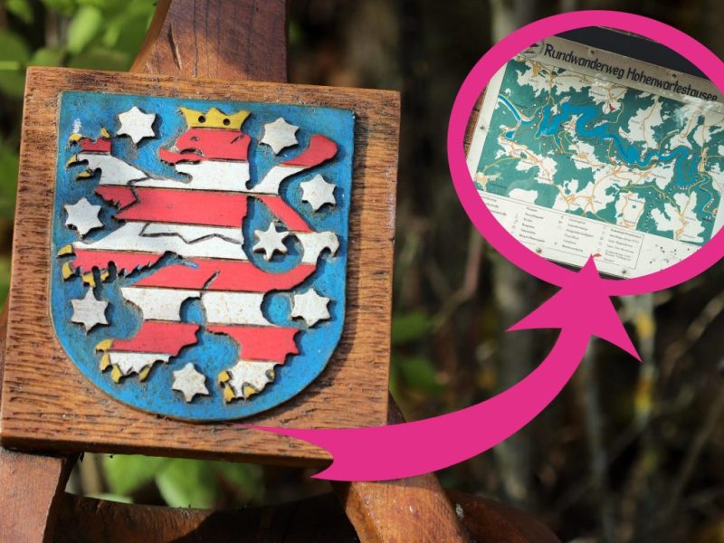 Das Thüringer Wappen in Holz geschnitzt mit einem Pfeil auf eine Karte vom Rundwanderweg am Hohenwartestausee.