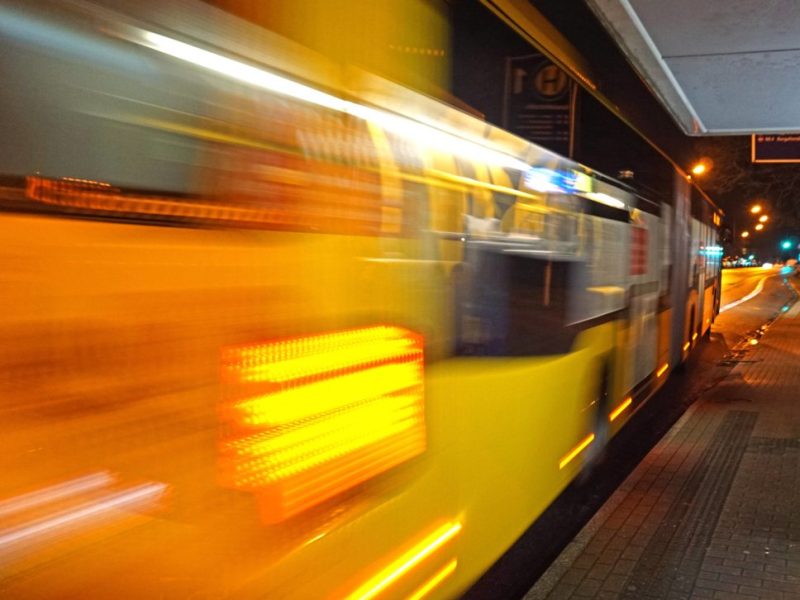 Ein Bus fährt an einer Haltestelle vorbei.