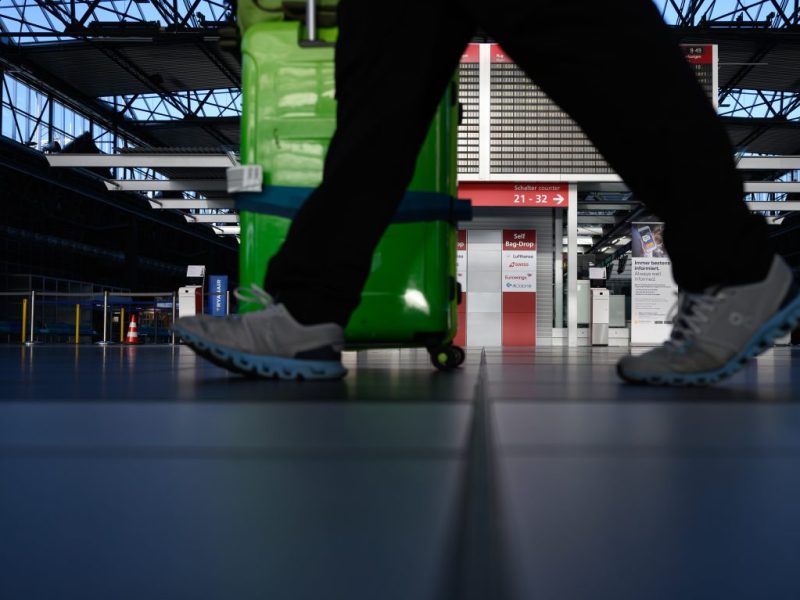 Ein Reisender schiebt seinen Koffer durch die Abflughalle am Flughafen Leipzig (Symbolbild)