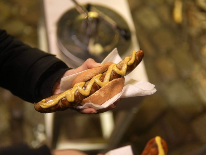 Ein Mann hält ein Brötchen mit einer Bratwurst in der Hand (Symbolbild Thüringen)